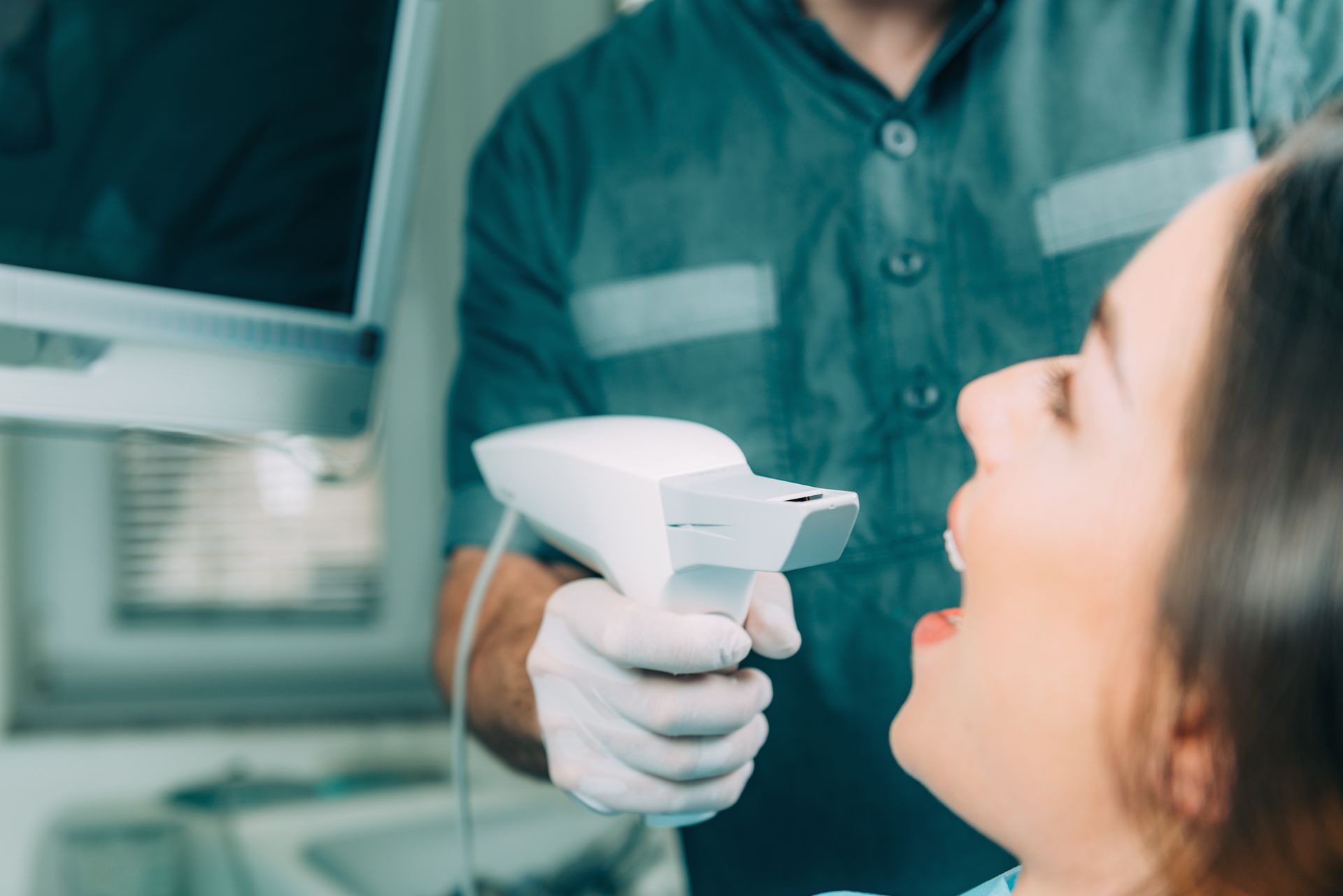 cosmetic dentists using a handheld intraoral scanner on a smiling patient during a whitening visit.