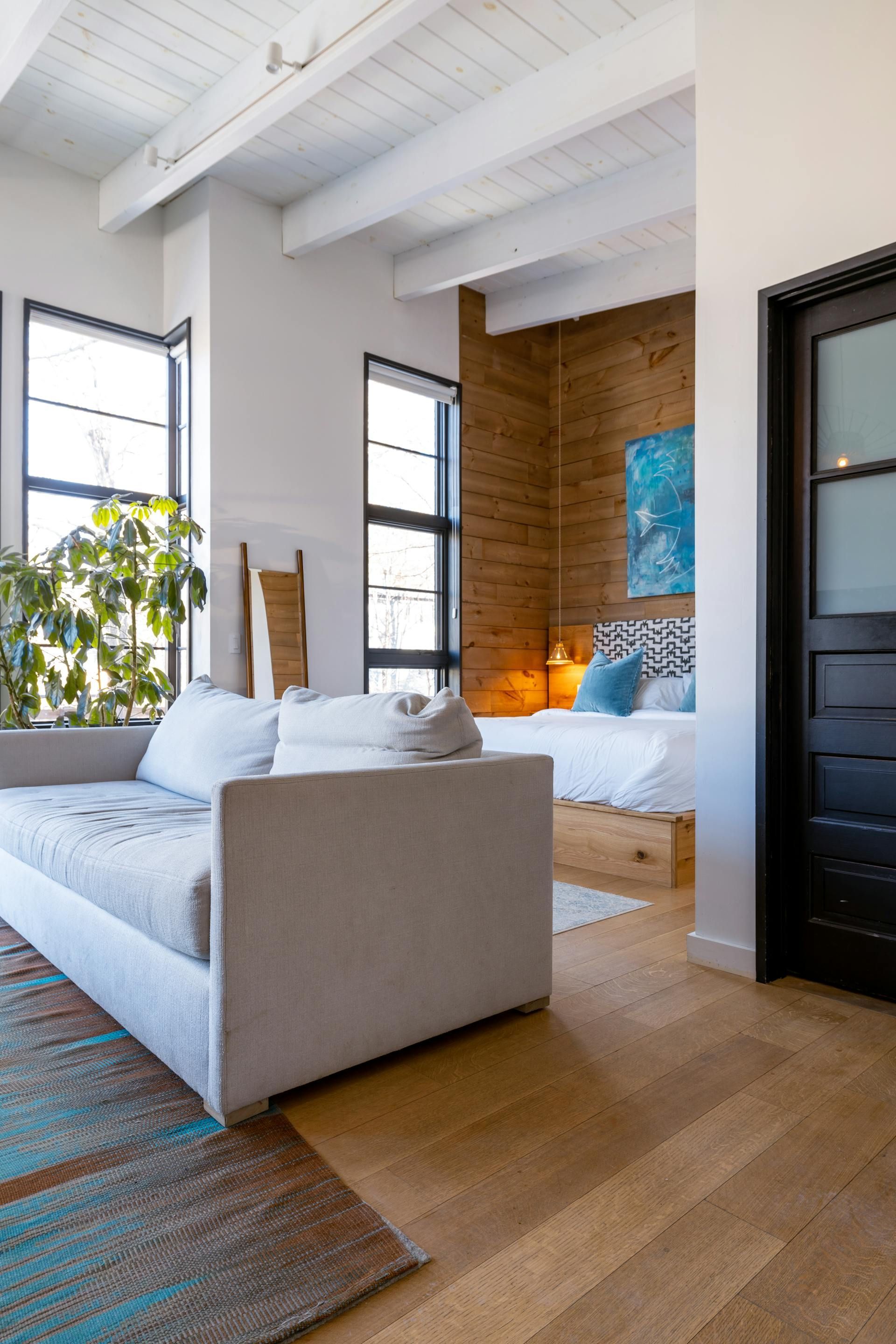 A living room with a couch and a bed in it.