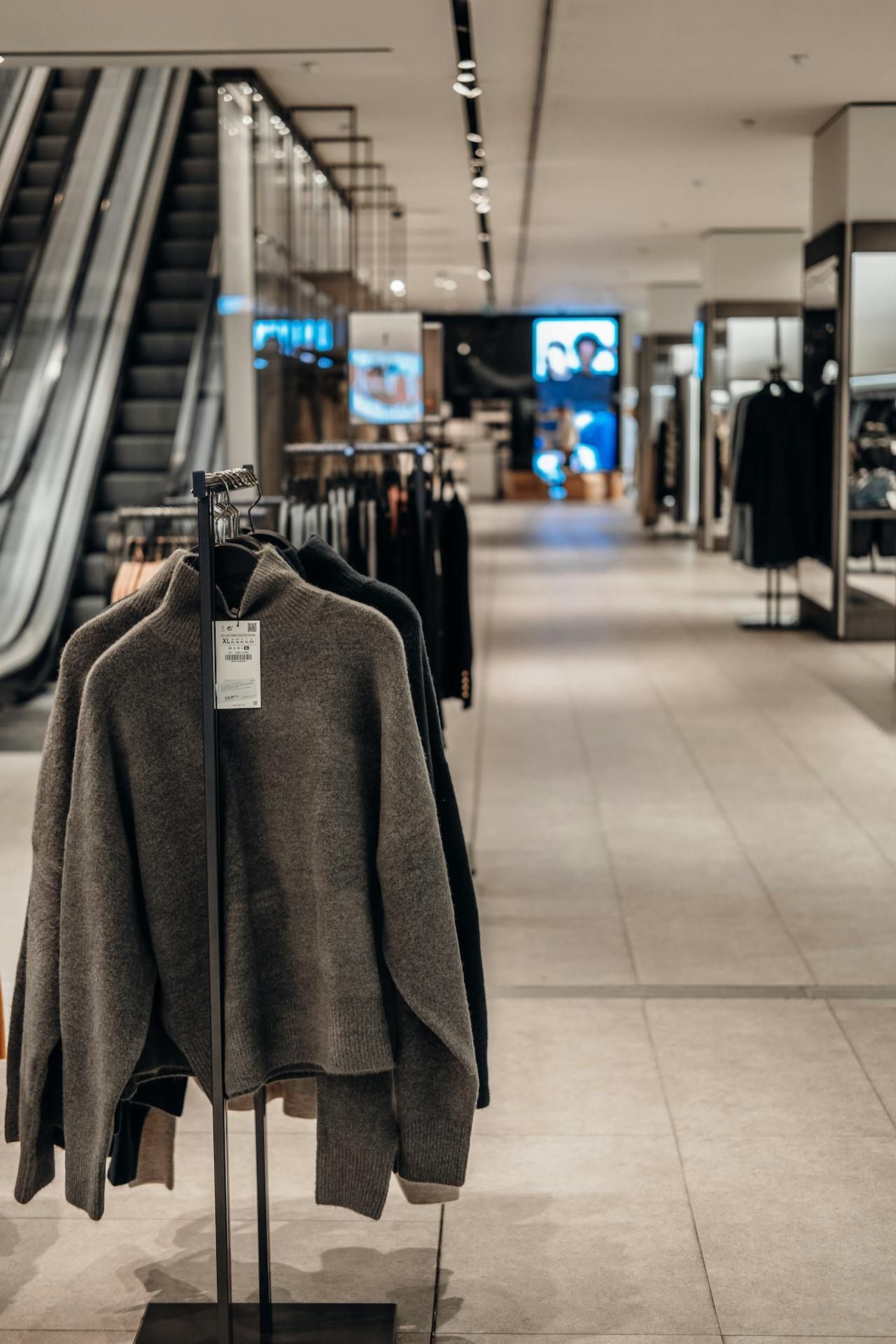A sweater is hanging on a rack in a store.