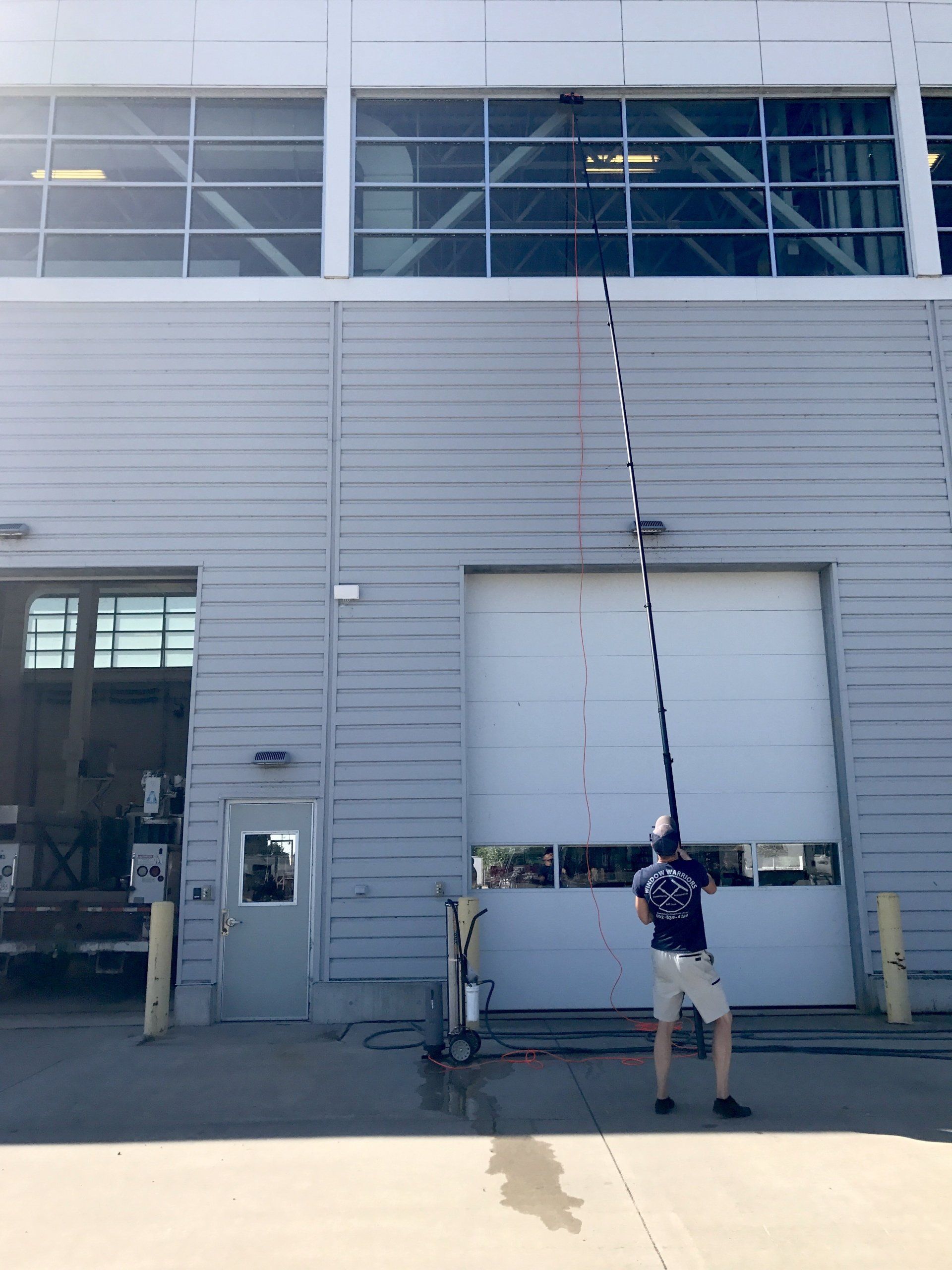 a man is cleaning a building with a long pole