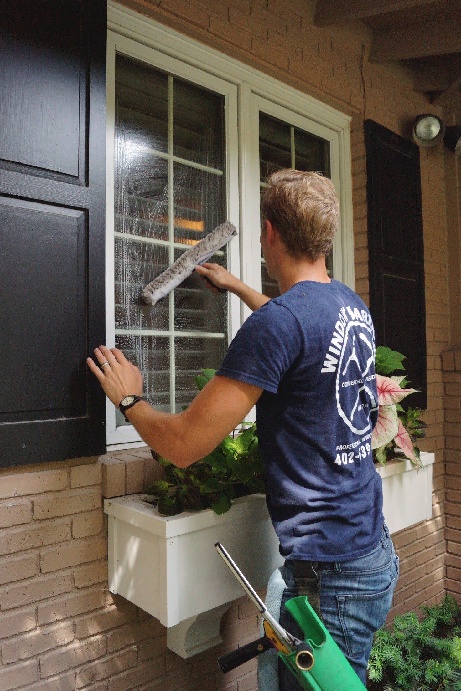 a man is cleaning a window with a squeegee .