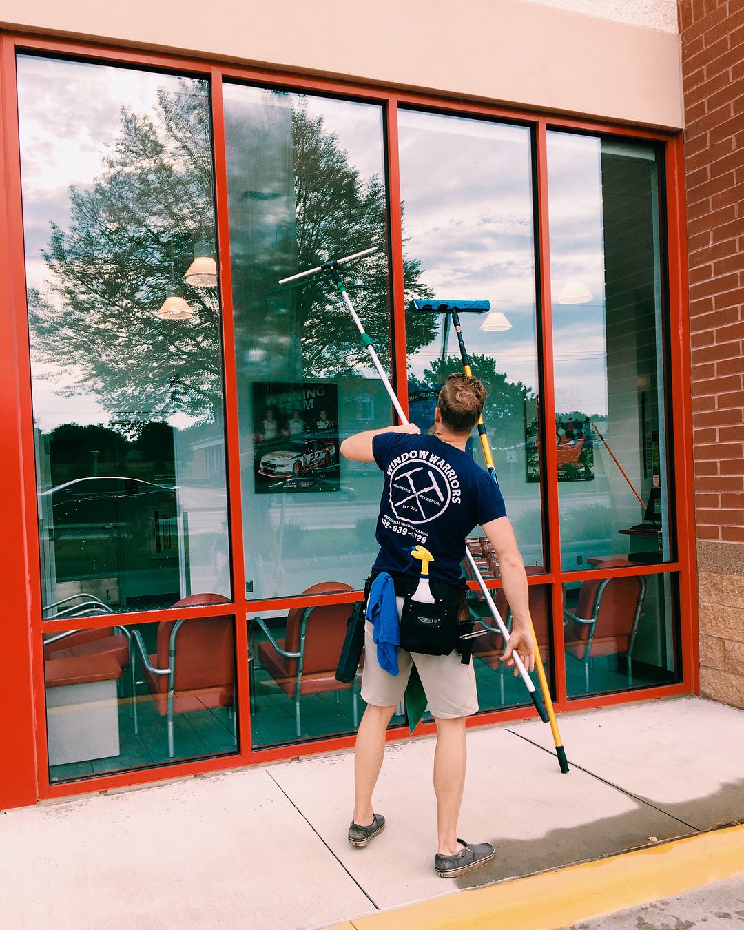 a man is cleaning a window with a squeegee .