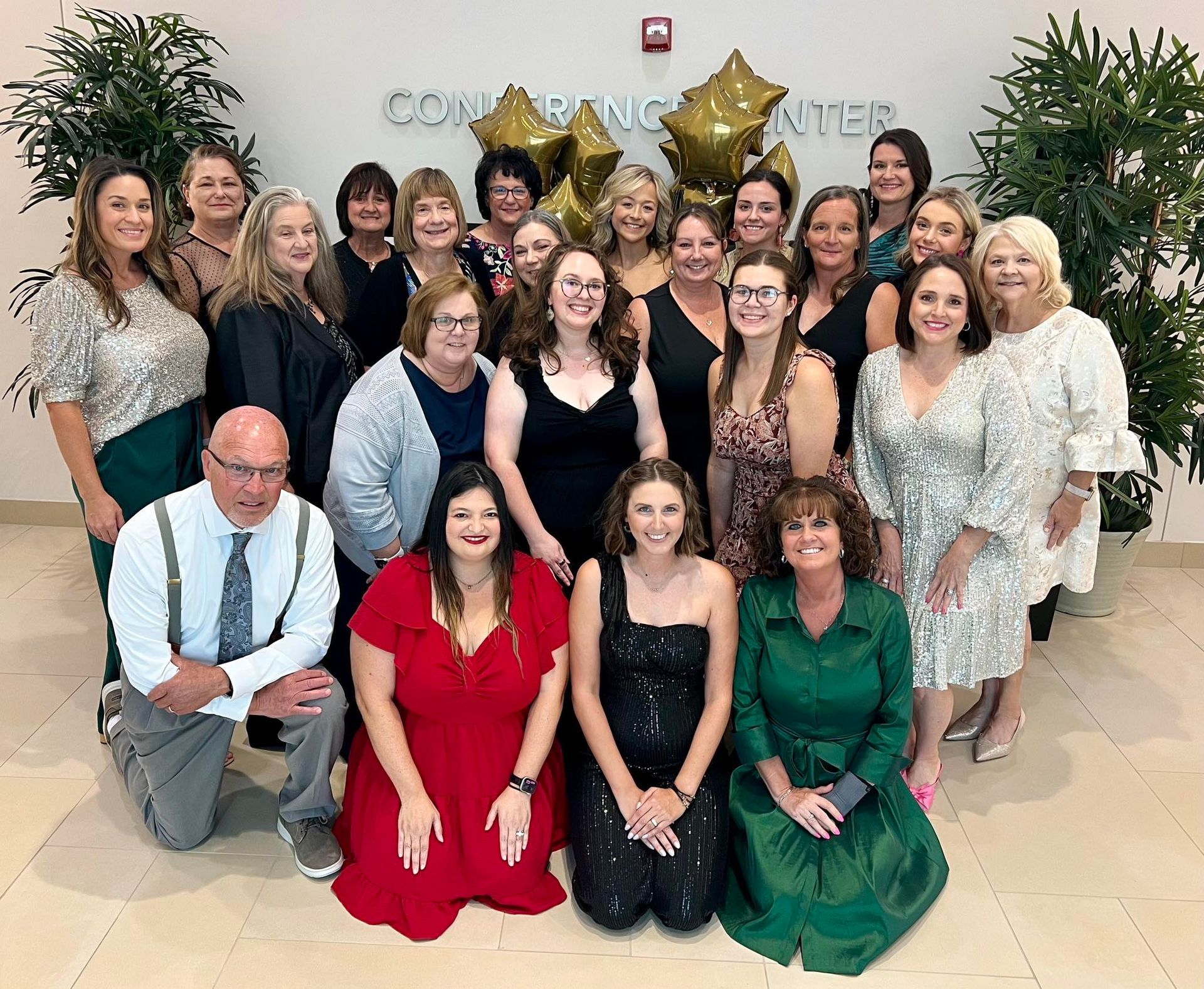 A girl in a white dress is holding a bible in front of a statue of mary