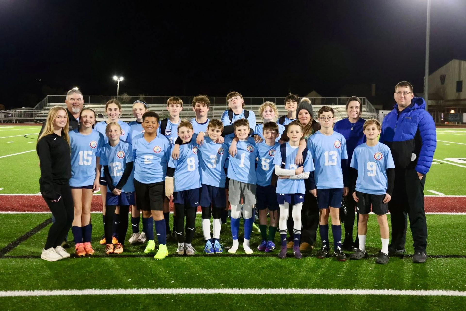 A girl wearing a shirt that says ' mardi gras ' on it