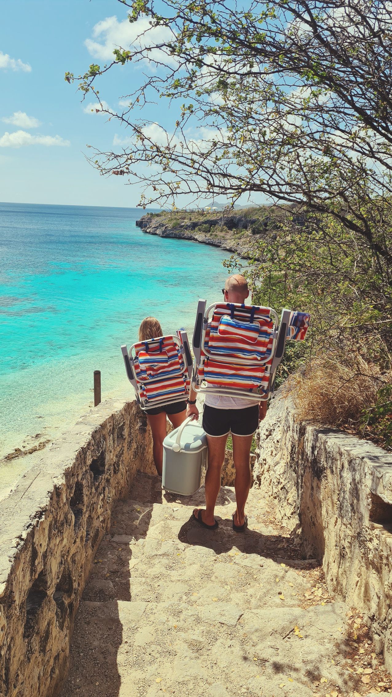 A couple on their way to Thousands steps with their rented beach chairs and cooler
