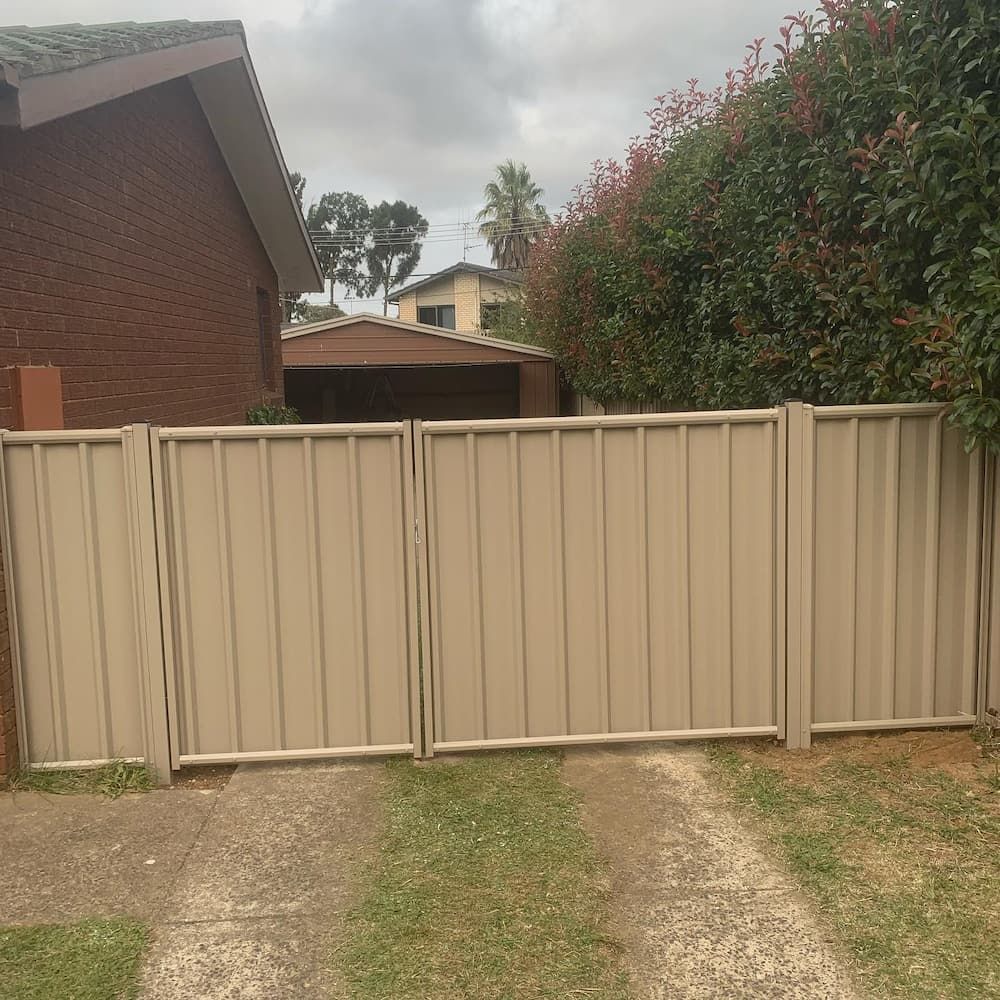 A Fence Surrounds a Driveway Leading to a House — CLF Landscaping In Hawker, ACT