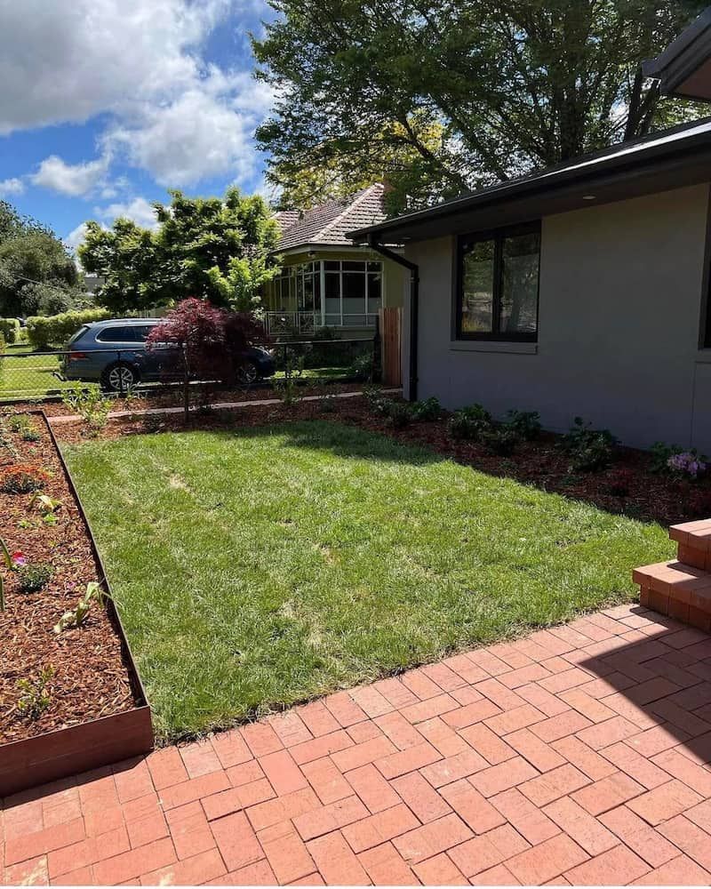 A House With a Large Lawn and a Brick Patio in Front of It — CLF Landscaping In Hawker, ACT