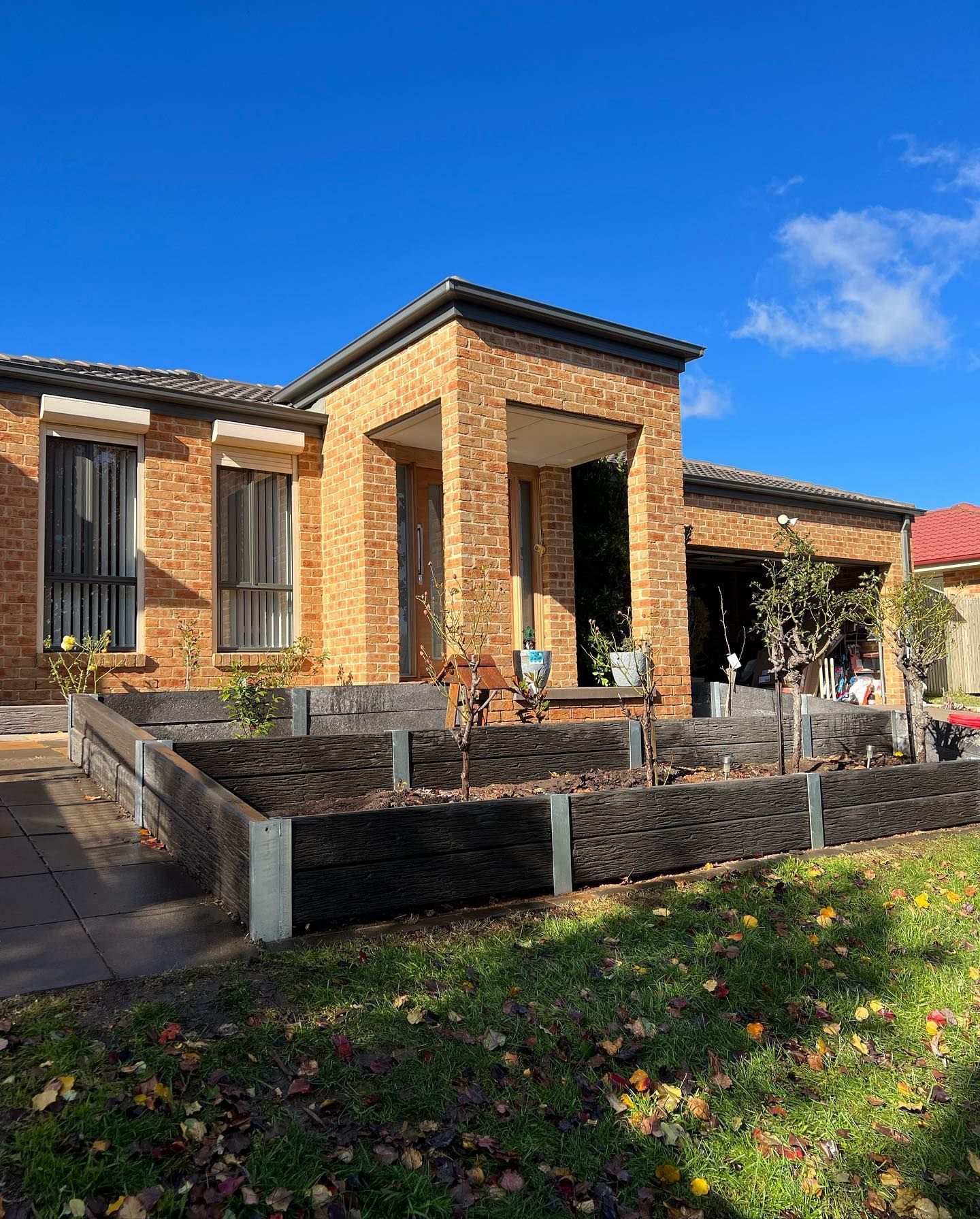 A Brick House With A Lush Green Yard In Front Of It — CLF Landscaping In Hawker, ACT