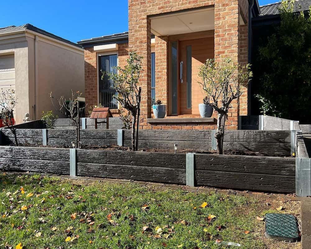A Brick House With a Wooden Fence in Front of It — CLF Landscaping In Hawker, ACT