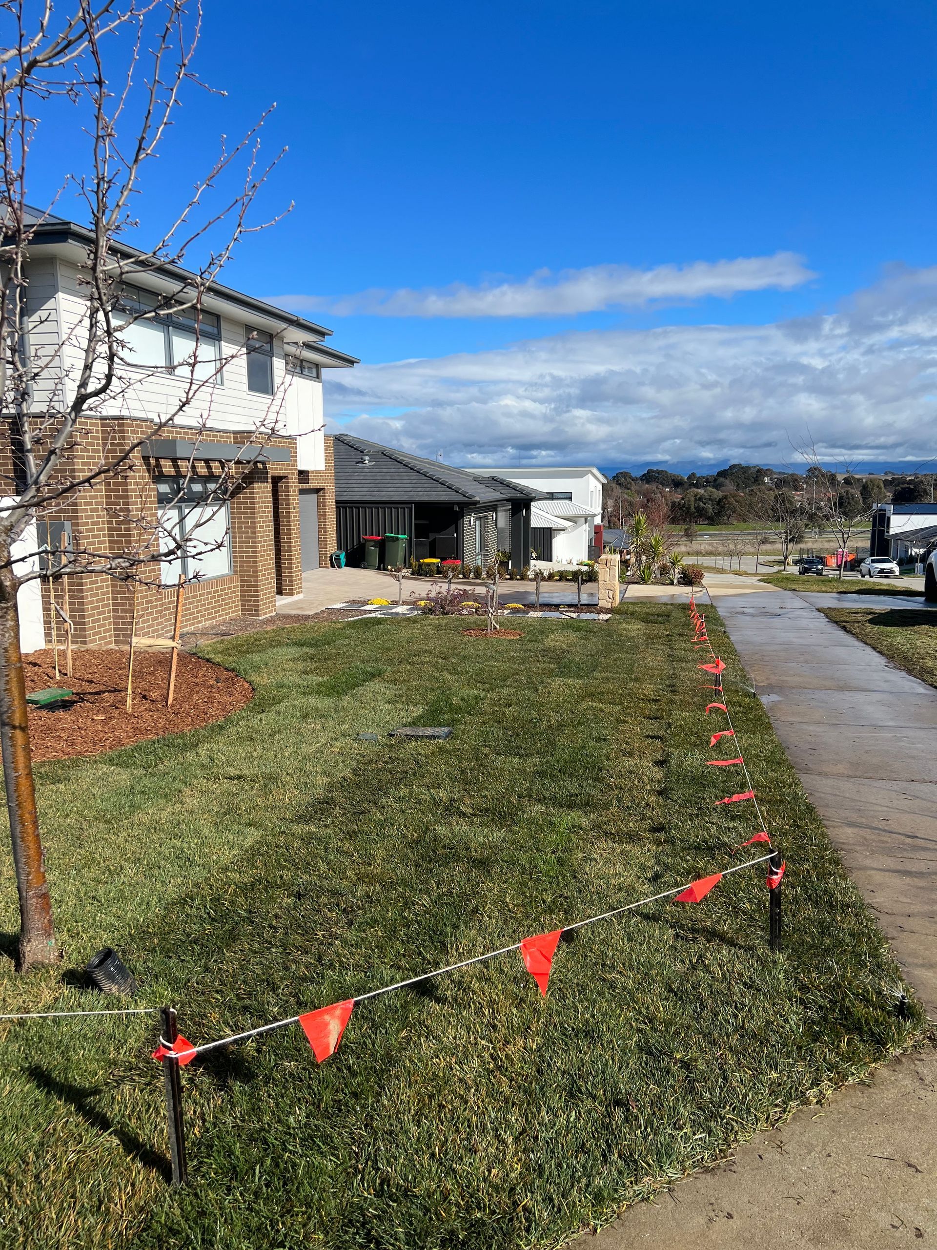 A large Green Lawn in Front of A House in a Neighbourhood — CLF Landscaping In Hawker, ACT