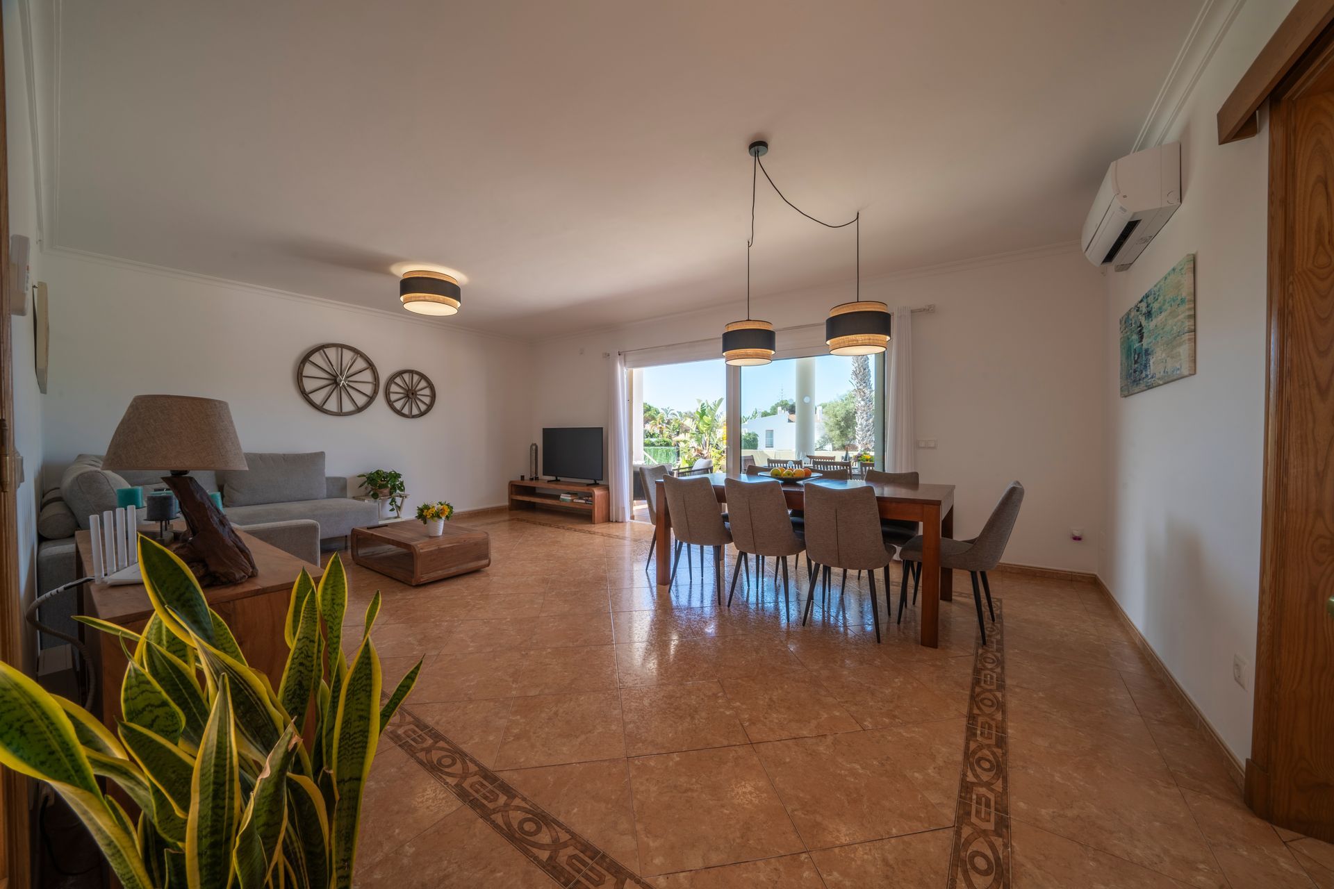 Amplia sala de estar y comedor con una gran mesa cerca de un balcón.