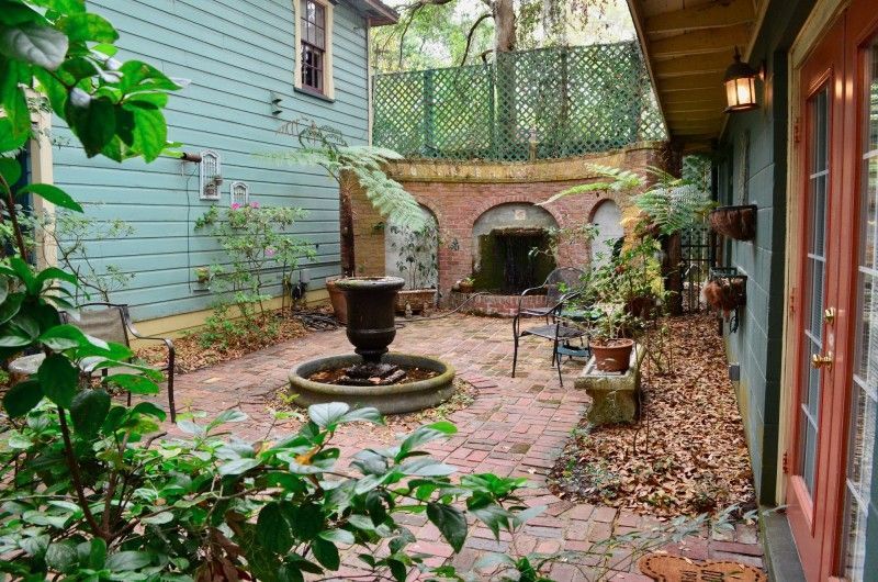 a brick courtyard with a fountain in the middle of it