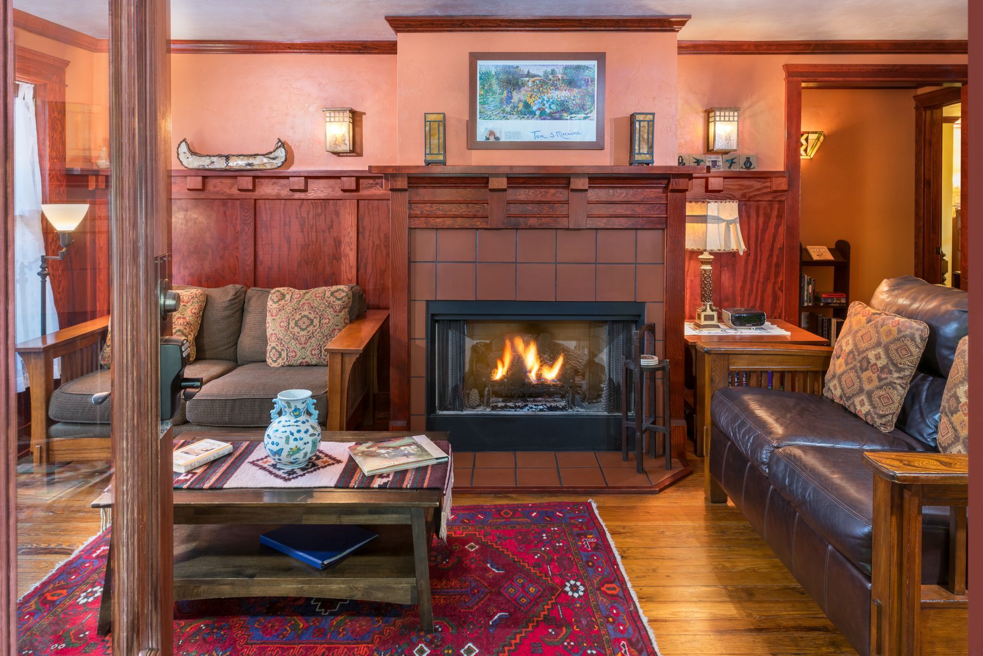 Living room shot with warm couches and a fireplace