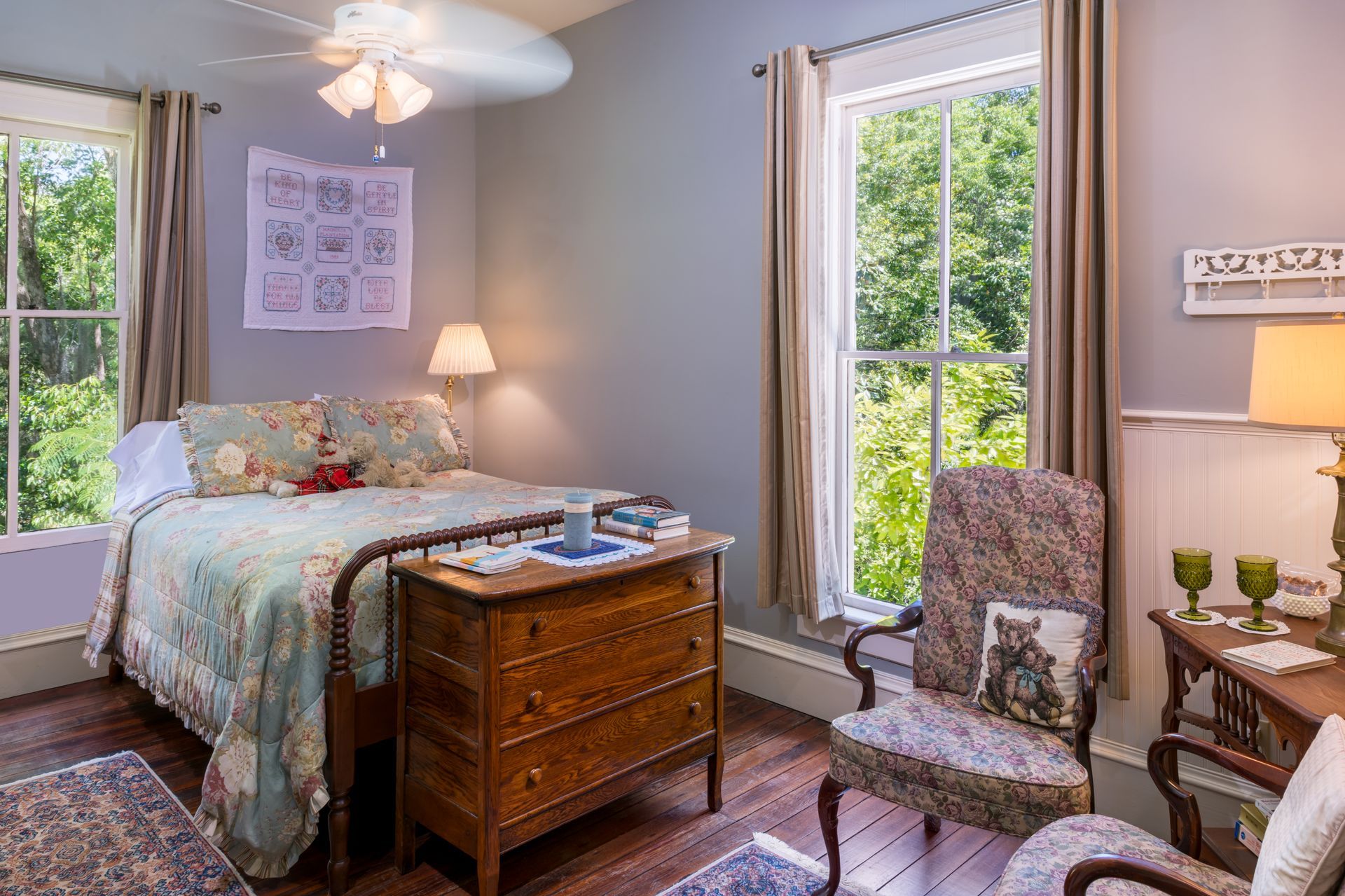 a bedroom with a bed , chair , nightstand , lamp and green walls .