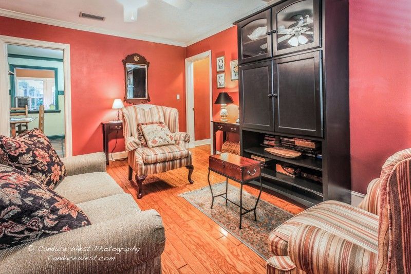 a living room with a couch , chair , table and entertainment center .