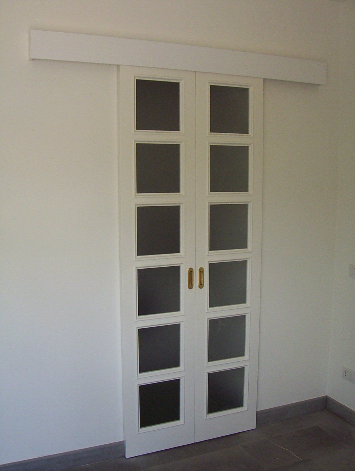 porte scorrevoli in vetro con struttura in legno laccato bianco