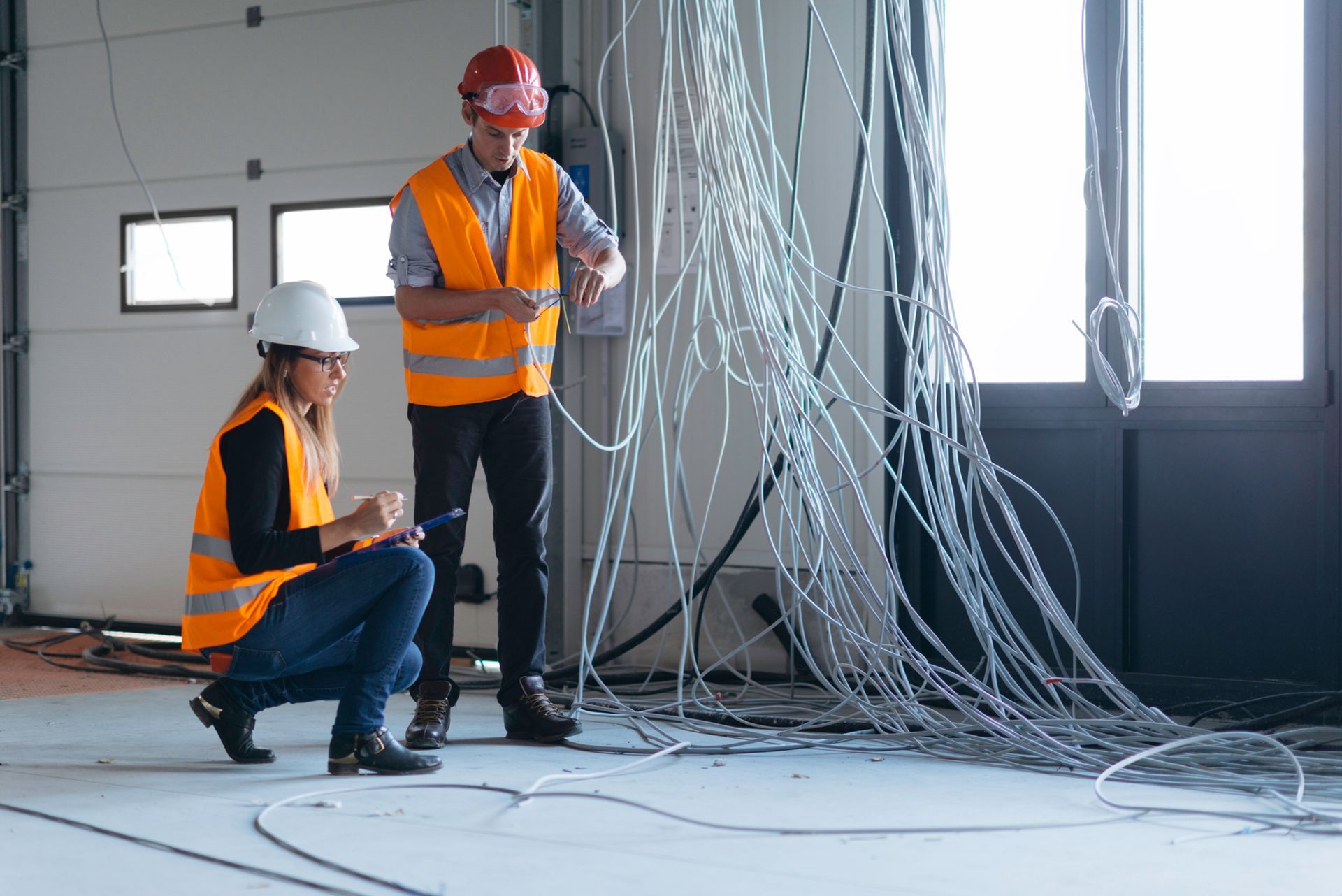 man and woman fixing electrical wiring