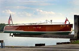 A wooden boat is sitting on top of a dock next to a body of water.