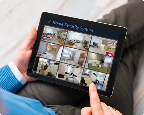 A person is holding a tablet with a home security system on it.