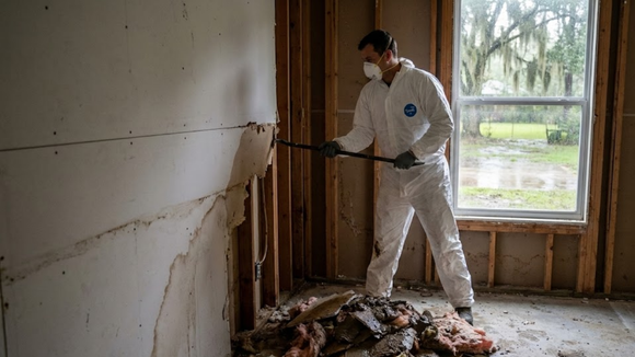Crew performing flood cleanup Alexandria services by removing damaged drywall.