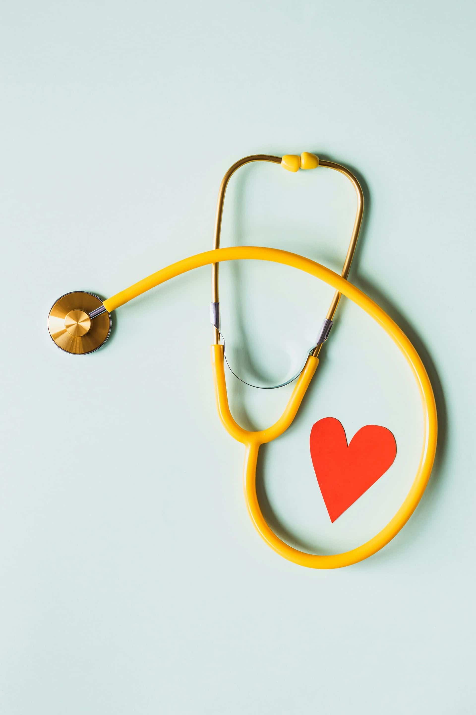 Stethoscope encircles a red heart on a pale blue background — One Stop Medical in Mackay, QLD