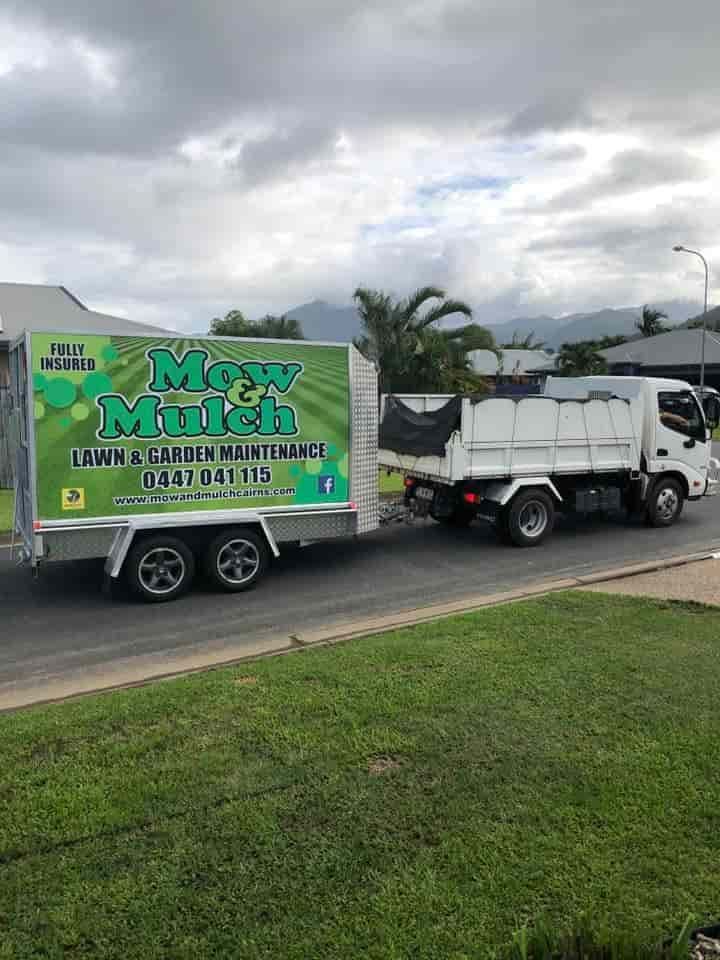 A Truck Is Towing A Large Trailer With The Business Logo On The Side And Driving On The Street — Mow & Mulch Lawn & Garden Maintenance In White Rock, QLD