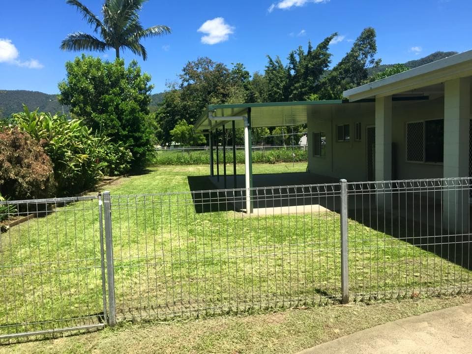 Green Lawn With a Metal Fence, Building With Carport and Trees — Mow & Mulch Lawn & Garden Maintenance In White Rock, QLD