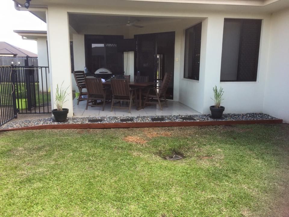 Back Patio With Outdoor Furniture, Flanked by Grass and Stone Border — Mow & Mulch Lawn & Garden Maintenance In White Rock, QLD