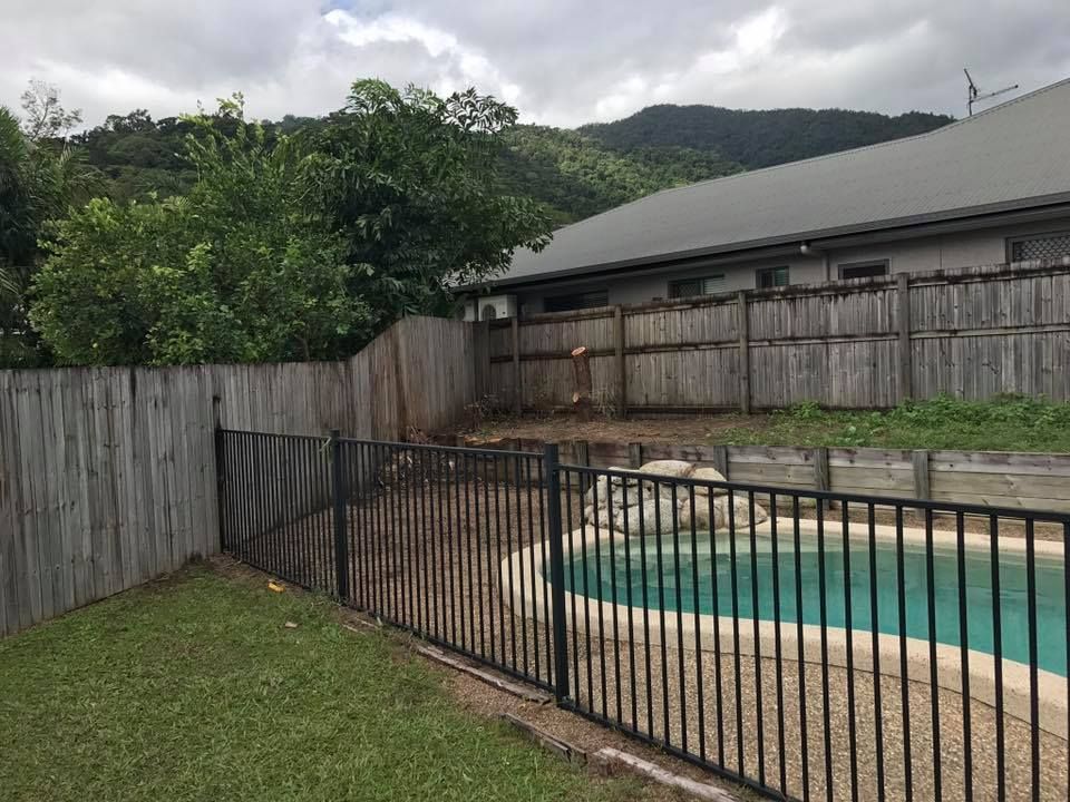 Backyard With Pool, Wooden Fences, and Mountain Backdrop Under Cloudy Sky — Mow & Mulch Lawn & Garden Maintenance In White Rock, QLD