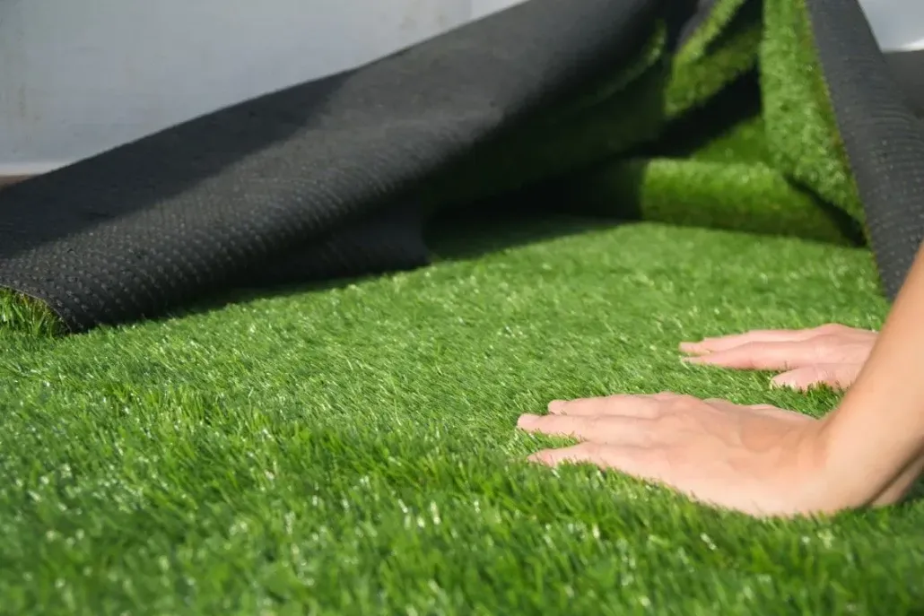 Professional installer smoothing out new synthetic turf.