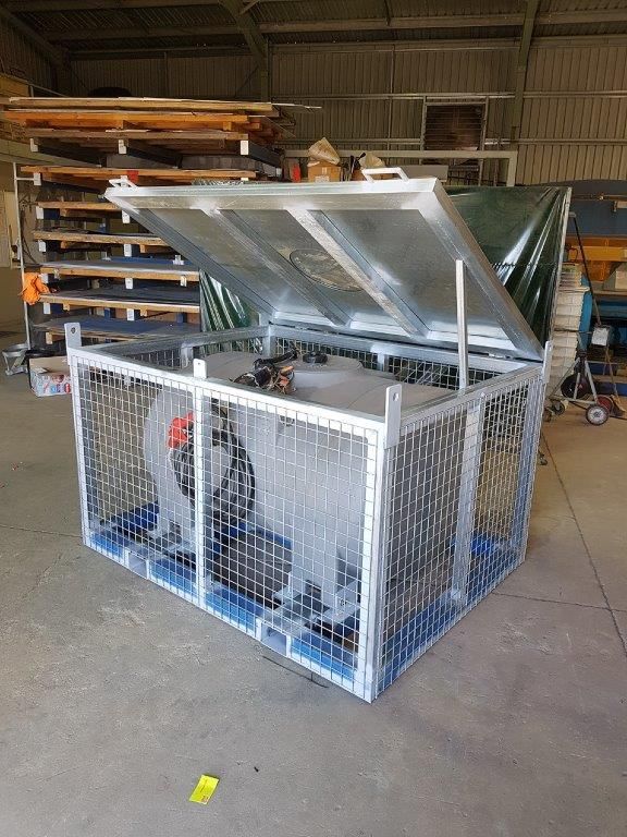 A metal cage with a lid is sitting in a warehouse.