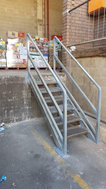 A set of metal stairs leading up to a warehouse.
