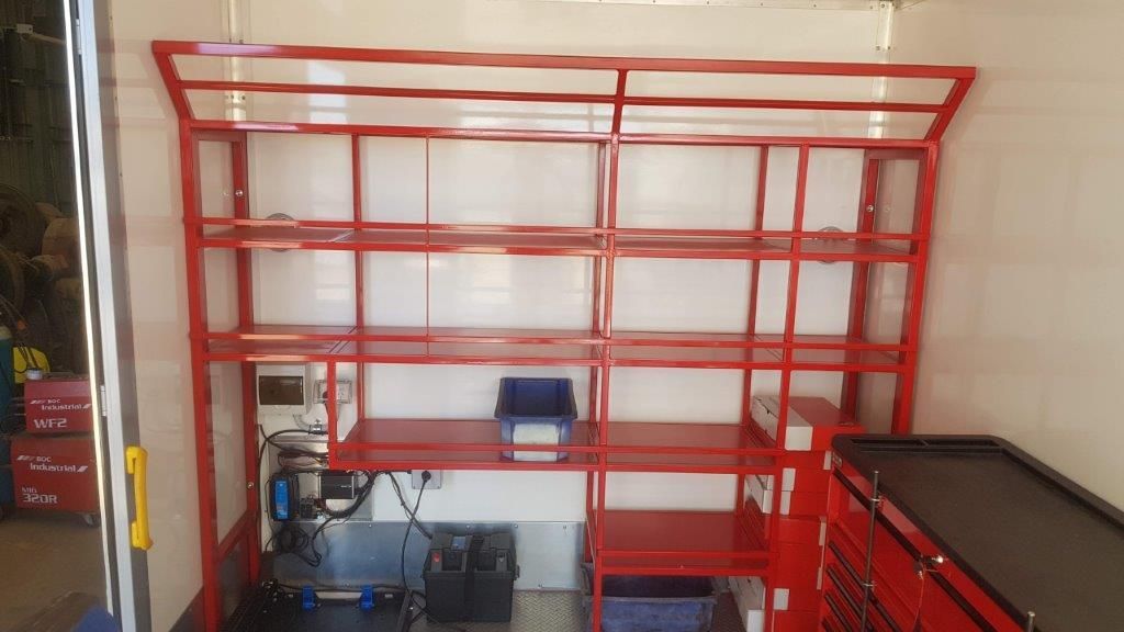 A room with red shelves and a black table