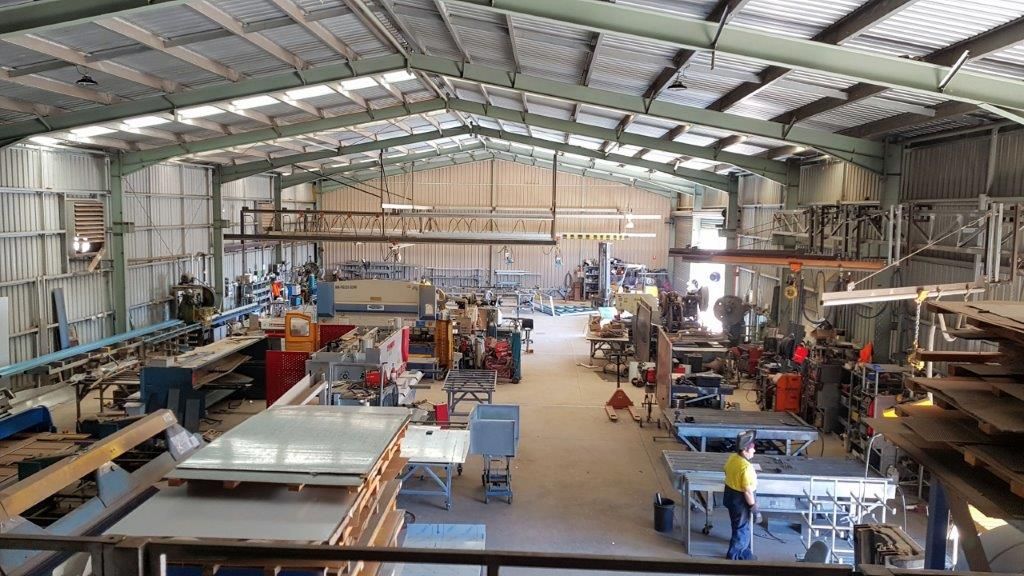 A large warehouse filled with lots of machinery and people.
