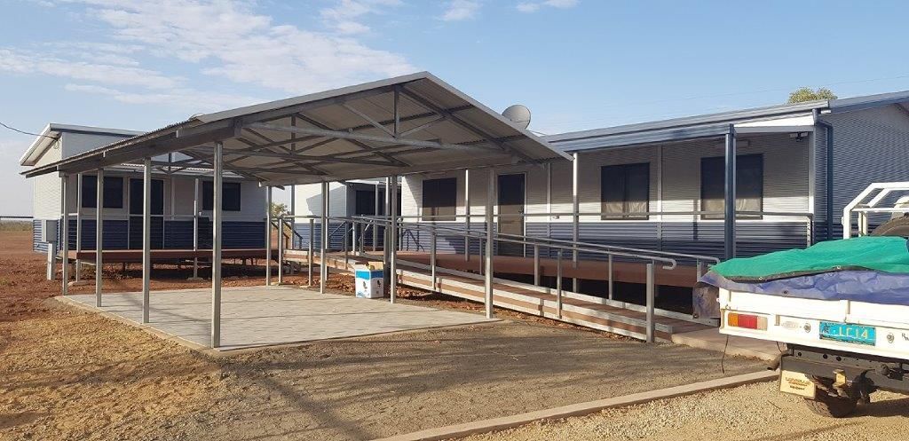 A truck is parked in front of a building with a canopy over it.