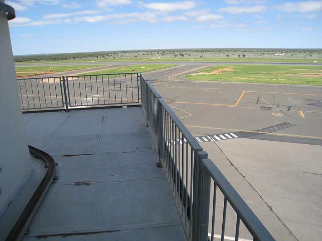 A view of a runway from a balcony with a railing
