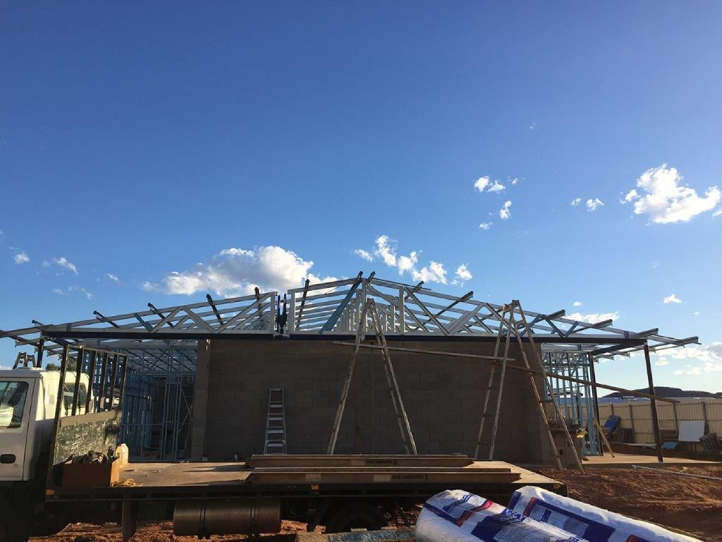 A truck is parked in front of a building under construction.