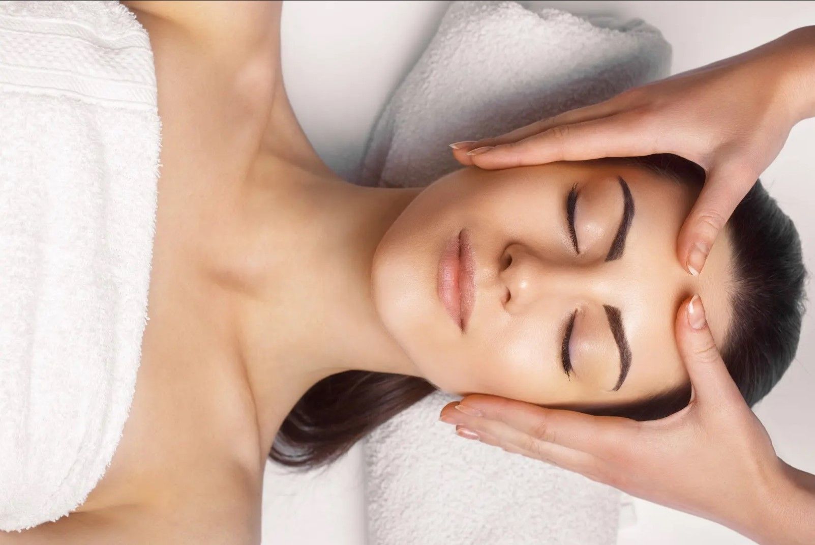 A woman is getting a head massage at a spa.