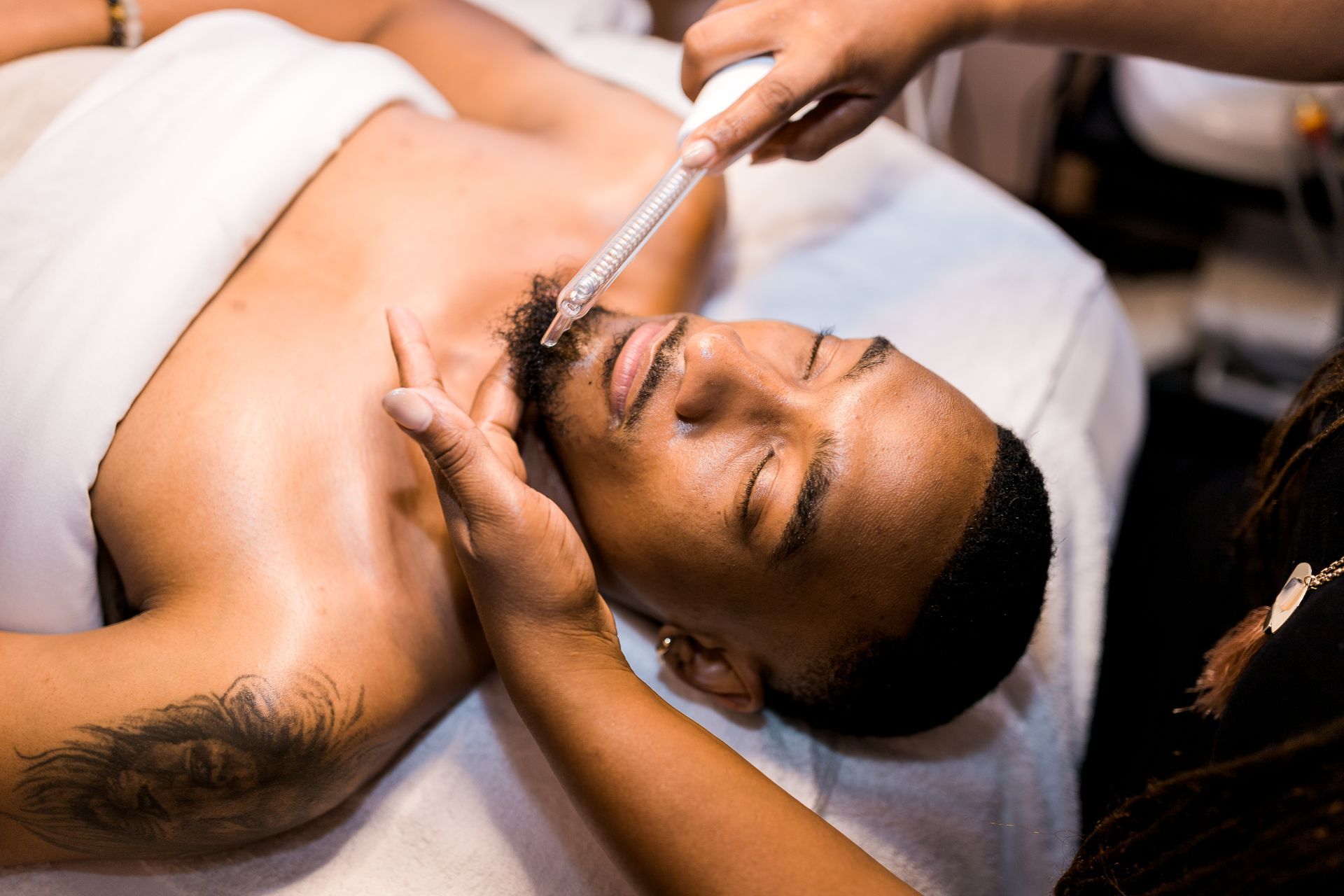 A man is getting a facial treatment at a spa.