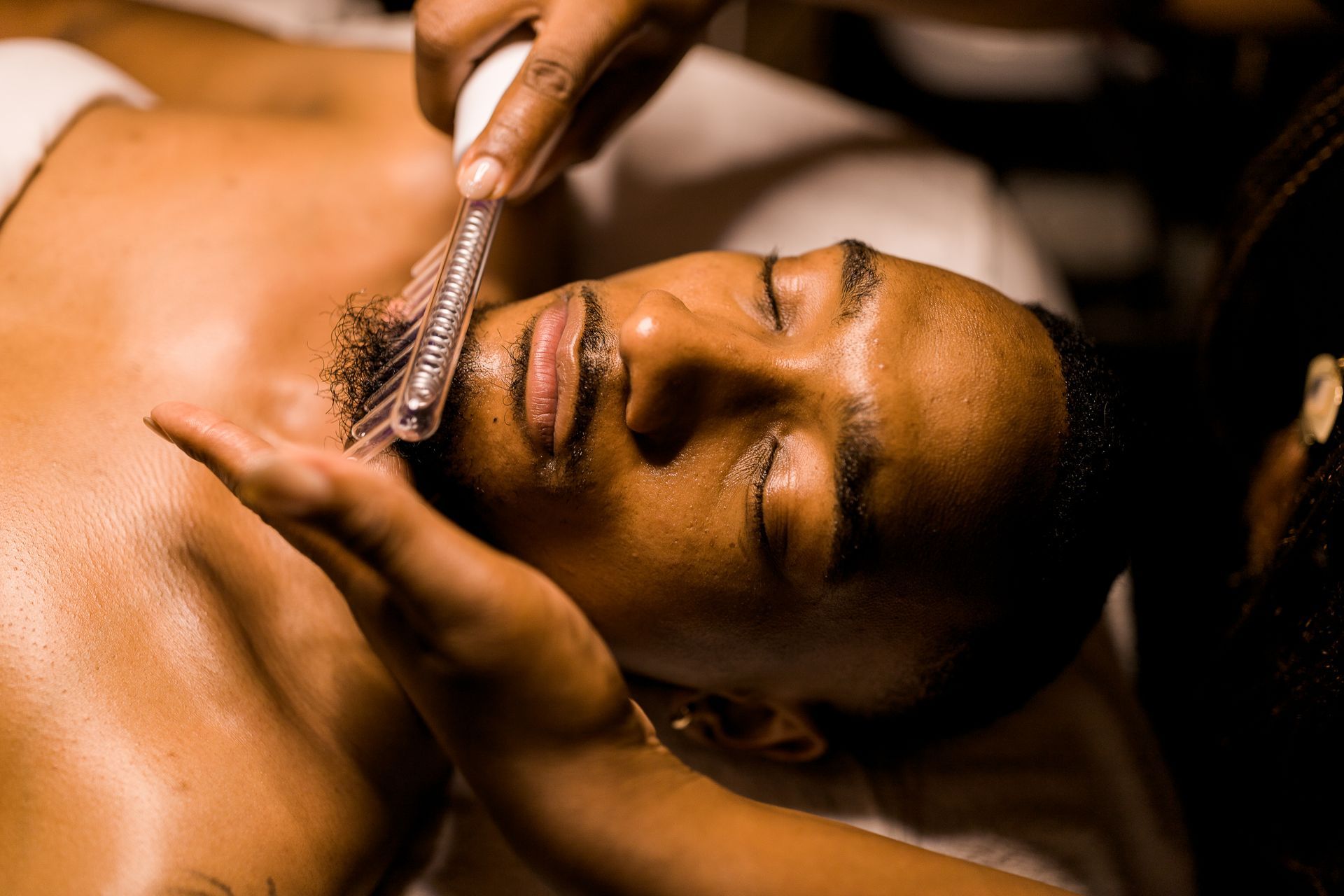 A man is getting a facial treatment at a spa.