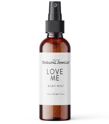 a bottle of love me body mist on a white background .