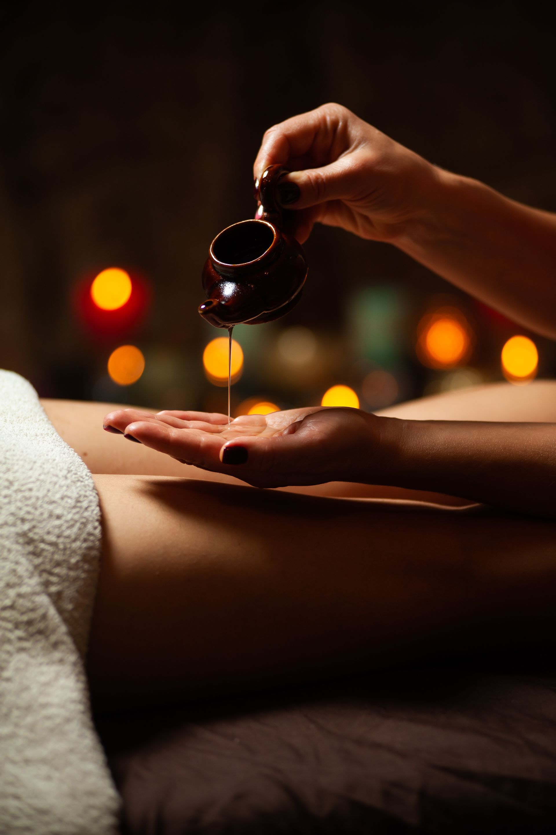 A woman is getting a massage with oil in a spa.