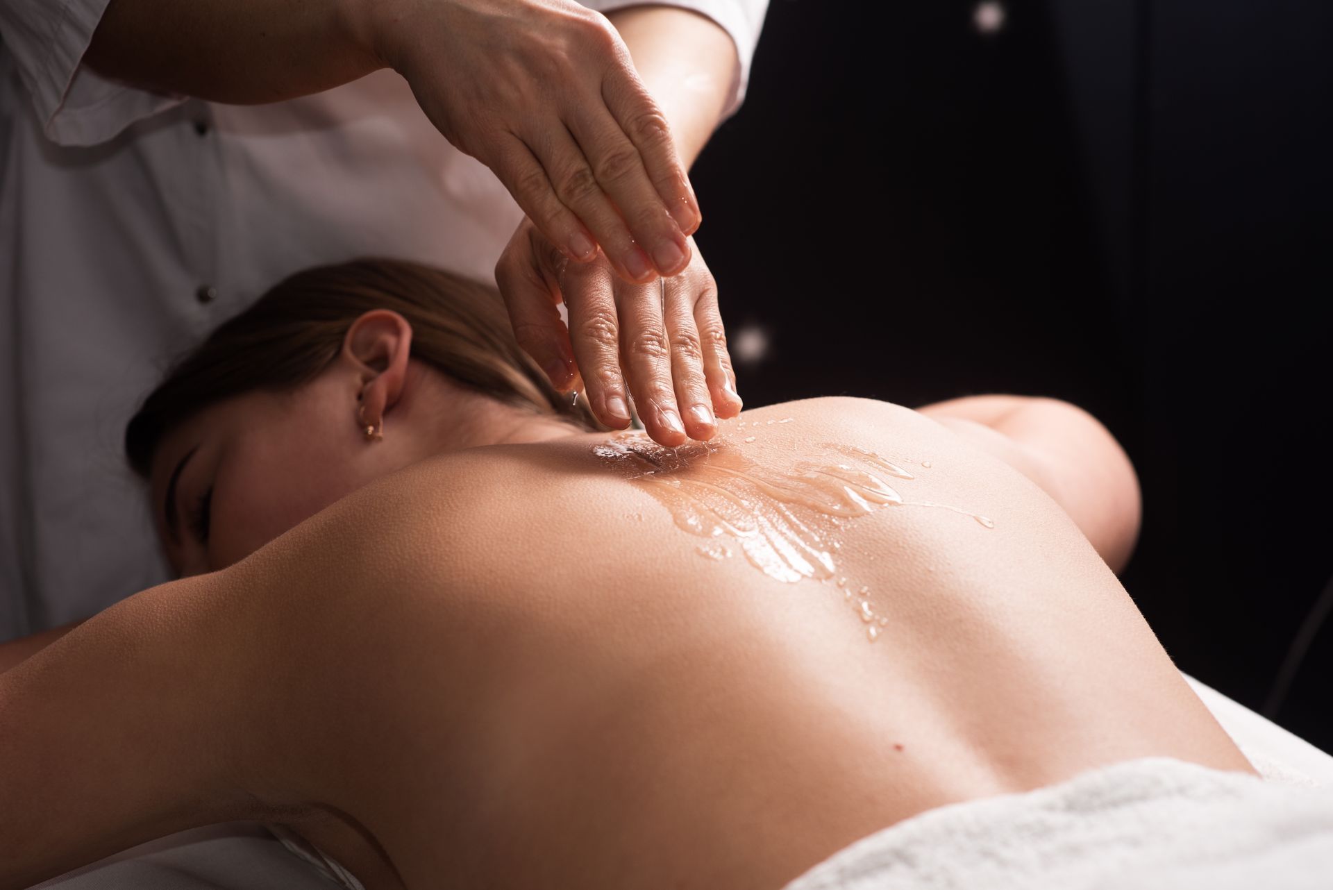 A woman is getting a massage on her back at a spa.