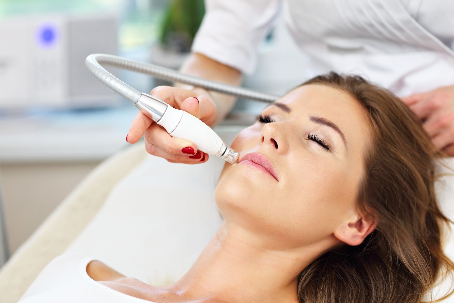 a woman is getting a microneedle treatment on her face .