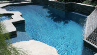 A large swimming pool filled with blue water and surrounded by rocks.