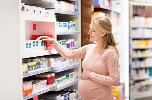 donna incinta sceglie medicinali in farmacia