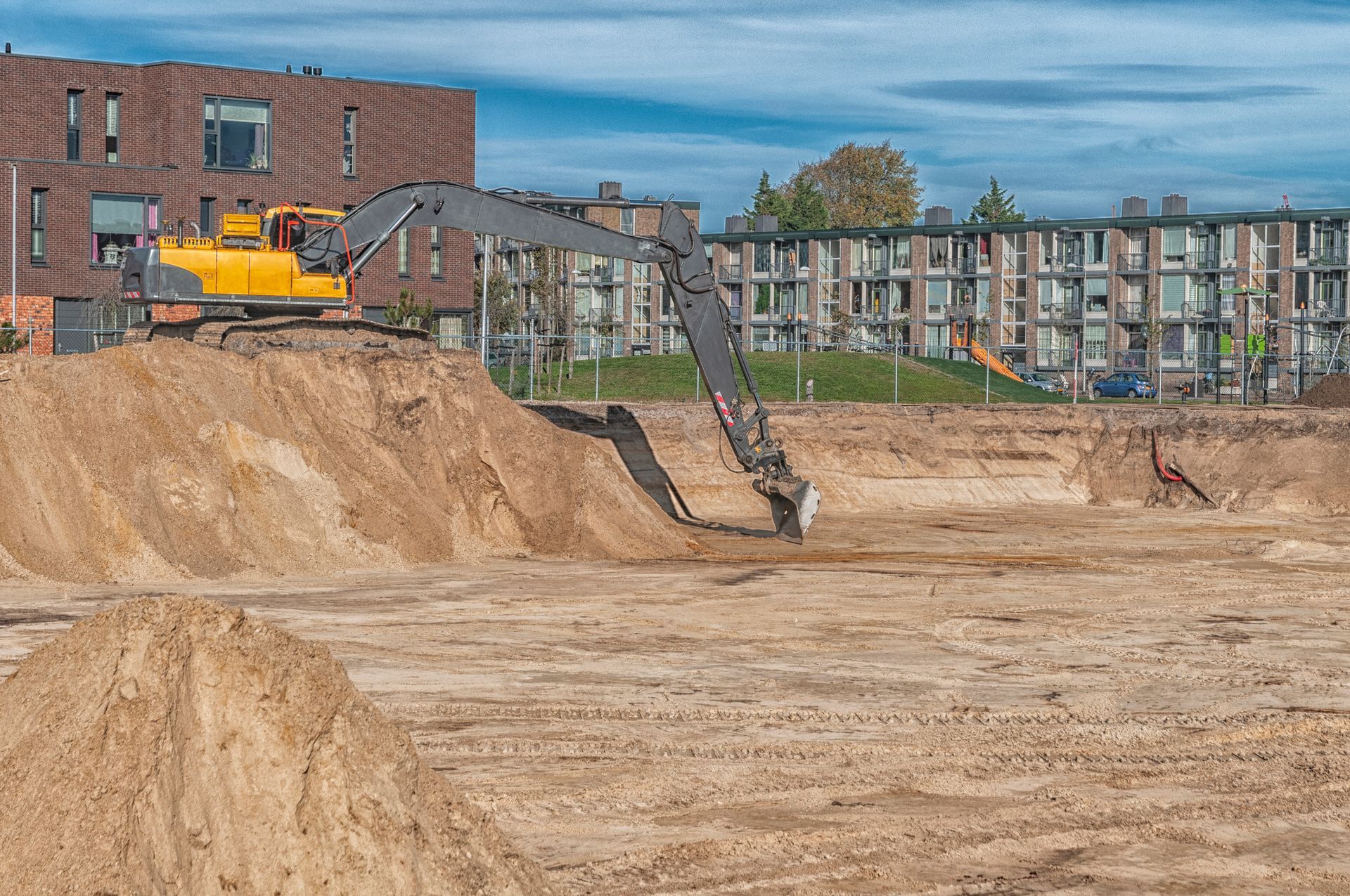 Excavator on top of a sand mountain on a building site