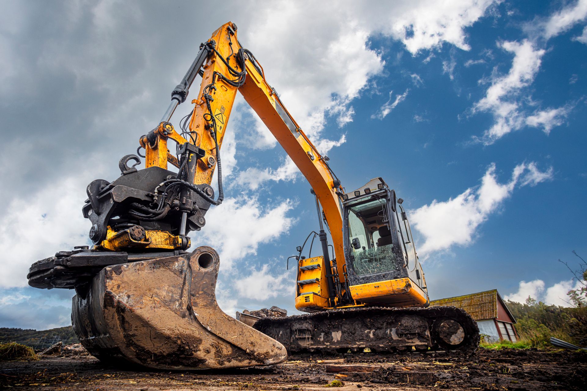 Local excavating contractor operating a yellow excavator on a construction site