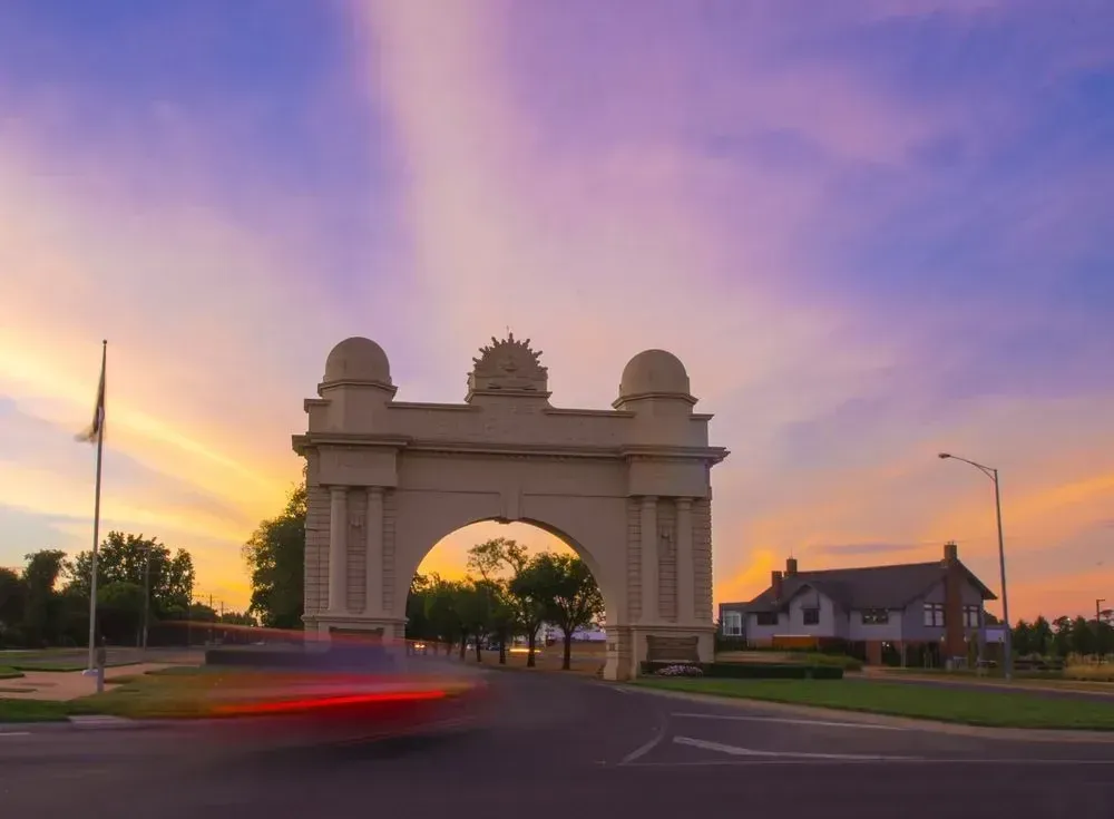 A Car Is Driving Past An Archway At Sunset — Spring Crest Blinds, Awnings & Security Doors in Ballarat, VIC