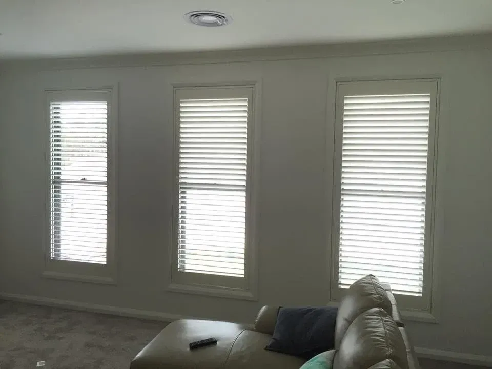 A Living Room With A Couch And Three Windows With Blinds — Spring Crest Blinds, Awnings & Security Doors in Ballarat, VIC